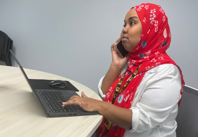 Samia Katun at her laptop and on the phone.