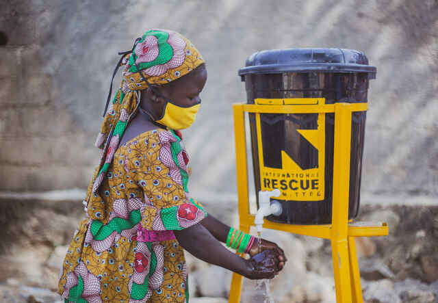 A woman washes her hands at a handwashing station