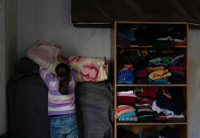 Ameera, 15, folds sheets in the bedroom that she shares with her siblings. She has learnt to adapt to her blindness thanks to the routines she has put in place. She makes her bed everyday by herself and succeeds in helping her sister and stepmother with house tasks.