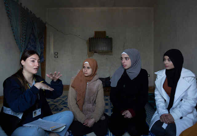 Sabah and other refugee girls sitting with IRC WPE Manager Elissar Hababe