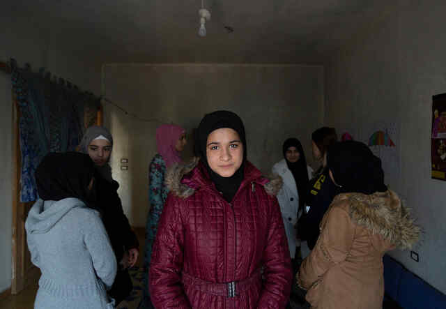  Syrian refugee girl Khadija*, 14, stands in the middle of the room during a game led by IRC’s Women's Protection and Empowerment Manager Elissar Hababe, 33, 2nd right, in the safe place where Syrian refugee girls take part in different kind of activities led by the IRC team.