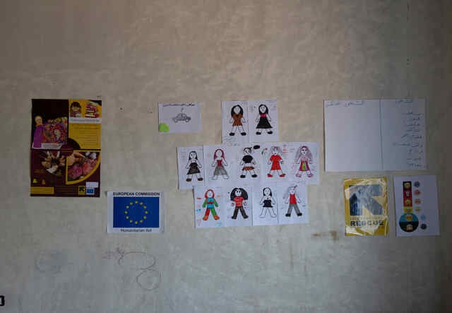 Different papers with drawings and writing, information and logos hang on the wall in the safe space where Syrian refugee girls take part in different kind of activities with the IRC WPE team.