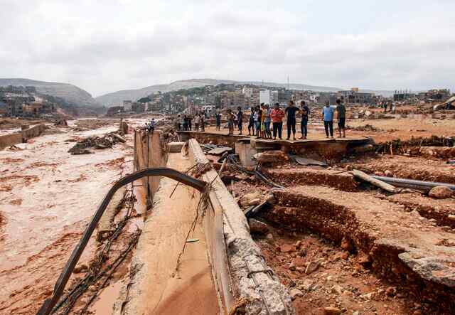 Eine Gruppe von Libyer*innen schaut sich die Überschwemmungsschäden nach dem Sturm Daniel an.