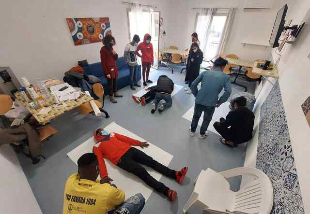 A group of young people taking part in an info session at a reception center in Italy.