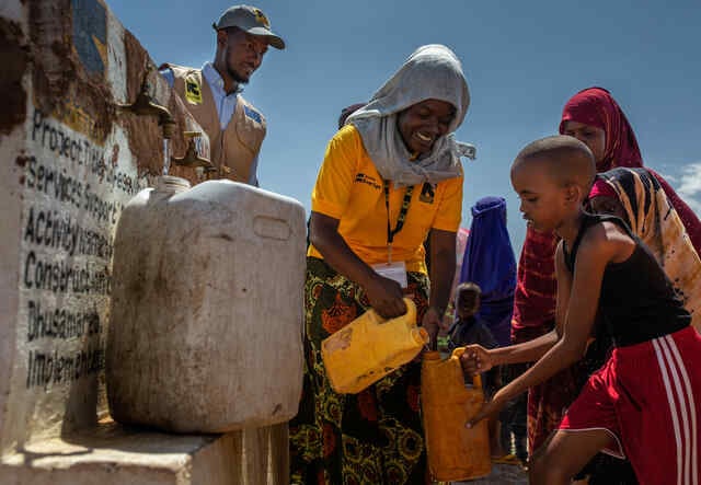Rescue:s medarbetare hjälper en pojke att fylla på vatten vid en vattenbrunn i Dhusamareb, Somalia.