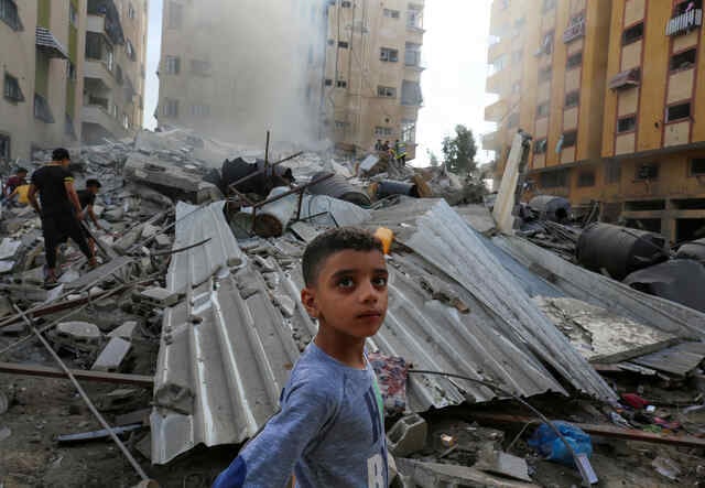 People assess the destruction cause by Israeli air strikes in Gaza City on October 7, 2023.