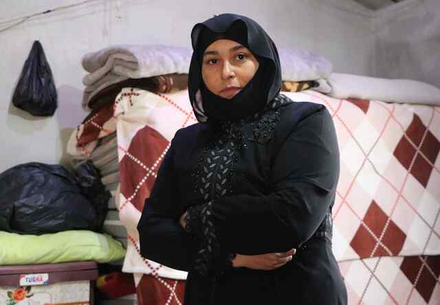 Mustafa poses with her arms folded in a sewing studio.