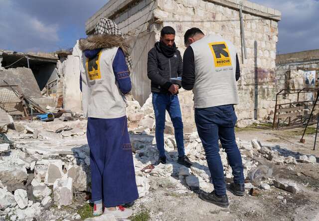 Two IRC cash assistance staff members assess the needs of an earthquake survivor in Syria.