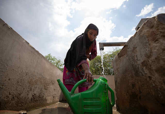 En kvinna fyller på vatten vid en vattenbrunn i staden Sindh.