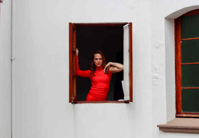 Candy poses in a window frame, facing the camera.