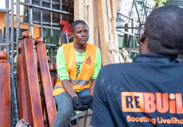 Rahma [in orange] faces the camera, talking to a colleague.