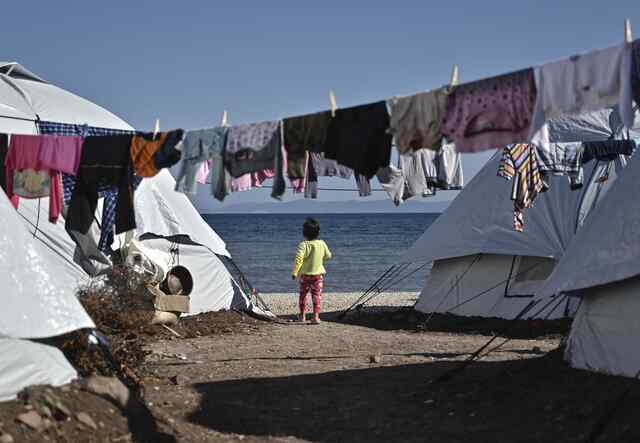 Ett barn går bland tält på flyktinglägret i Lesbos, Grekland. 