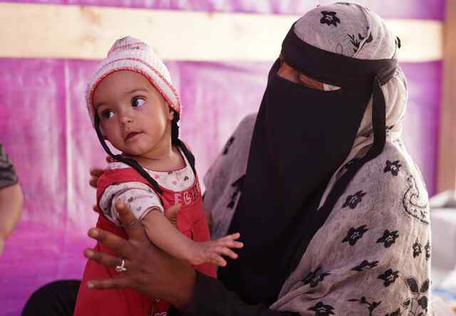 Yemeni mother Asriya holding her baby daughter.