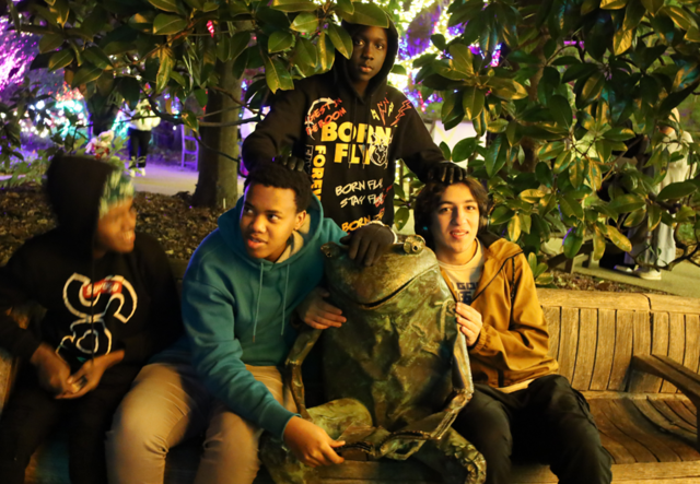 Youth Futures students sitting with a frog statue at the Atlanta Botanical Garden.