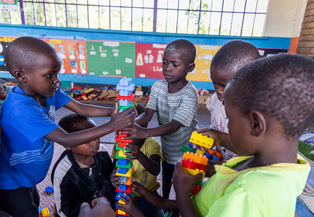 Students work together to build a tower of LEGO bricks.