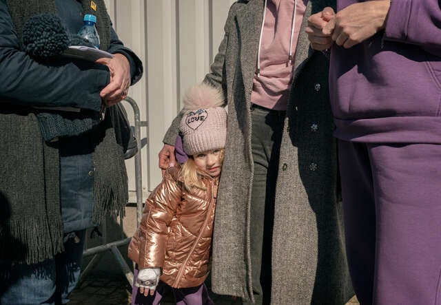 En liten flicka på flykt från kriget i Ukraina står vid gränsövergången i Medyka, Polen. 