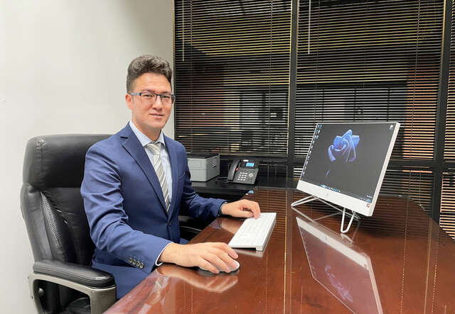 Naimat sitting at his desk.