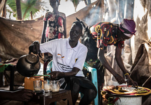 En kvinna serverar te på hennes restaurang i Nyal, Sydsudan. Hon har fått ekonomiskt stöd av RESCUE för att starta en restaurang.