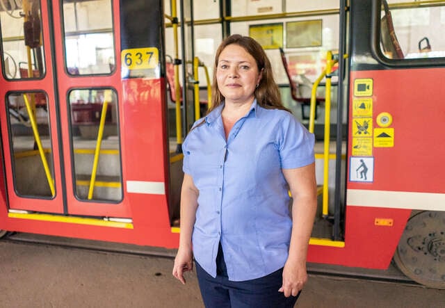 Maryna stands in front of a tram