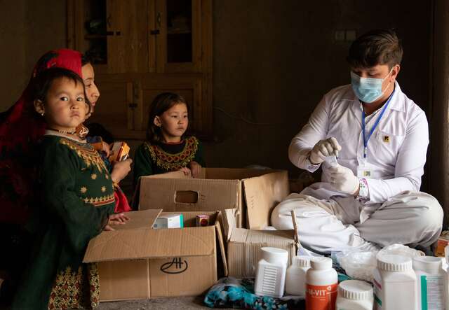 Rozama with her children collecting their medication from IRC pharmacist Hussain Ali.