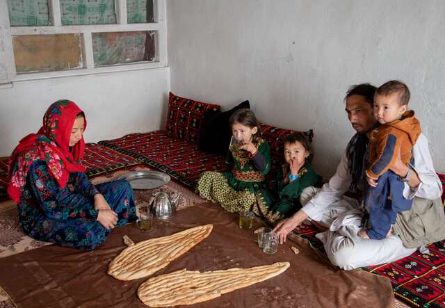 Rozama and her family sit in their home and have breakfast, which consists of fresh bread and green tea. 