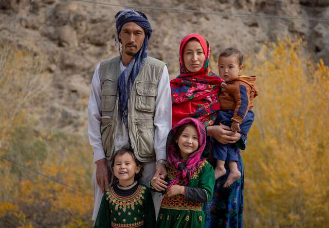 Rozama outside her house in Sabzaab Bala village, Bamiyan province, Afghanistan, with her husband, Mohammad Younis, and three children; Fatima, Fahmia, and Amir Ali. 