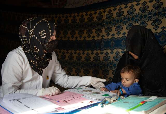 IRC counsellor Ruqia Moqtased examines Shams Ullah, in the lap of his grandmother, for malnutrition.