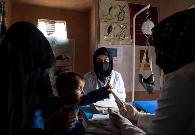 IRC nutrition counsellor, Najiba Rahimi, gives Shams Ullah nutrients to treat his malnutrition.