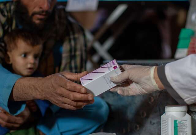 The IRC pharmacist, Nematullah Ayubi, gives Abdul Haq medication for his son at the IRC health clinic.