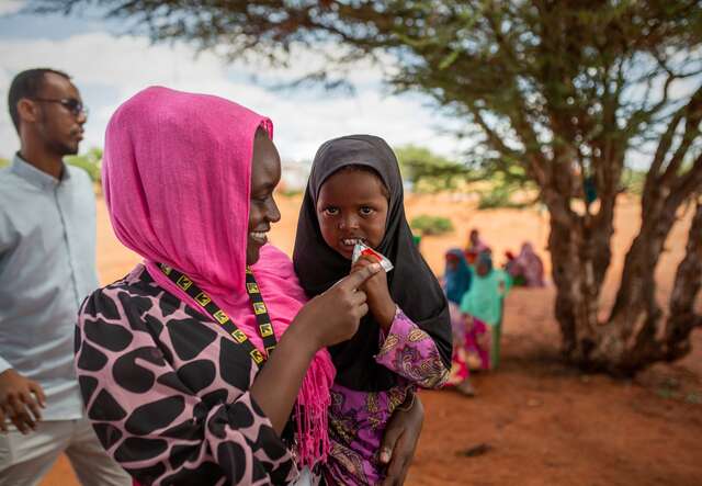 An IRC staff member provides a young child with malnutrition treatment.