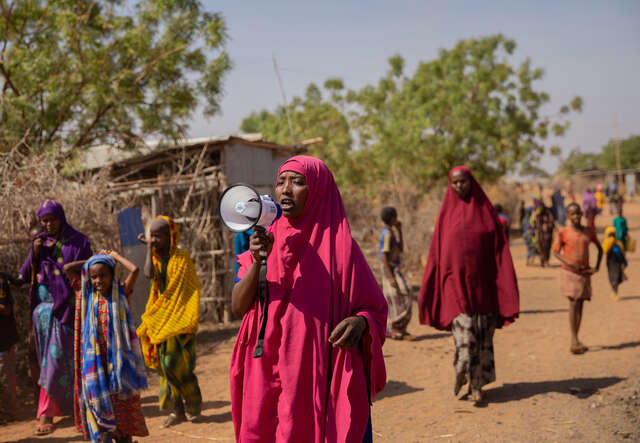 Eine Frau in Somalia spricht in ein Megaphon
