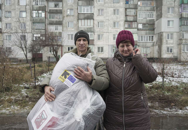 Syskonen Valentyna och Alexander i Ukraina bär på paket med skydd för vintern.. 