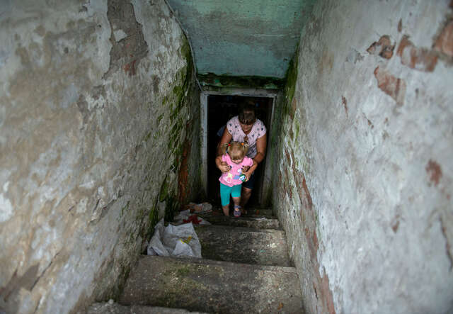 Tetiana and her 3-year-old daughter, Zlata, show the cellar where they shelter during bombings in Novyi Burluk village, Kharkiv.
