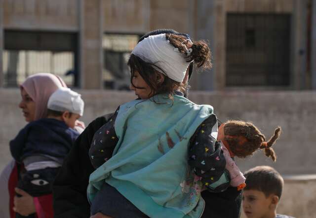 Mothers leave the hospital with their children after receiving treatment for injuries sustained in airstrikes in the neighborhoods of Idlib city, Syria.