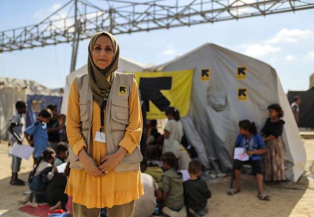 RESCUE:s personal i Gaza som arbetar med psykosocialt stöd står utanför ett tält där RESCUE:s logga syns.