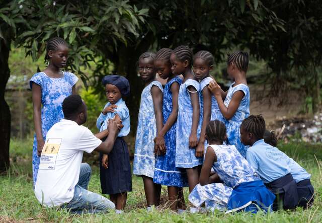 An IRC health care worker administers vaccines to students at a school in Sierra Leone.