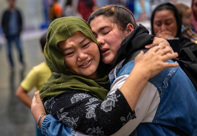 Two sisters embrace after they are reunited at an airport in the U.S.