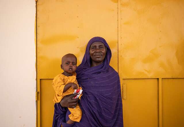 Safa smiles while holding her nephew, Mountasse, who was recently discharged from the IRC health clinic in Chad.