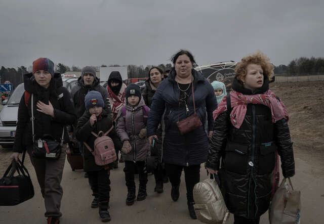 Människor på flykt från kriget i Ukraina vid en gränsövergång till Polen,