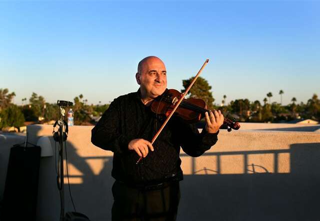 Fadi Iskandar performs violin before the Tucson World Refugee Day event.