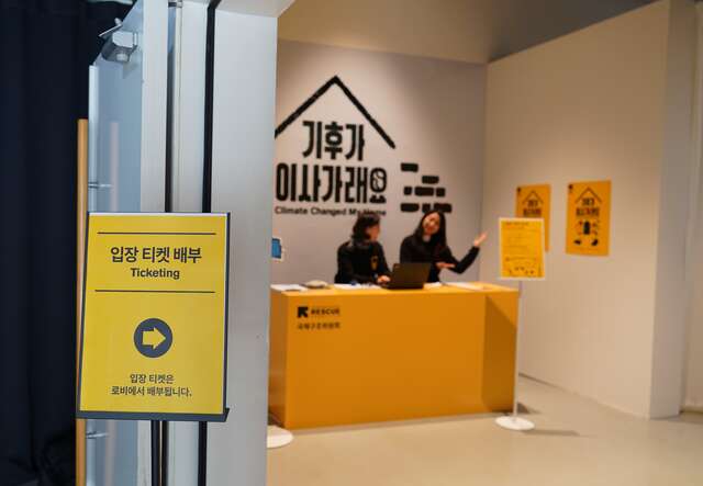 전시장 입구에서 국제구조위원회 직원들이 관람객을 반갑게 맞이하고 있습니다.