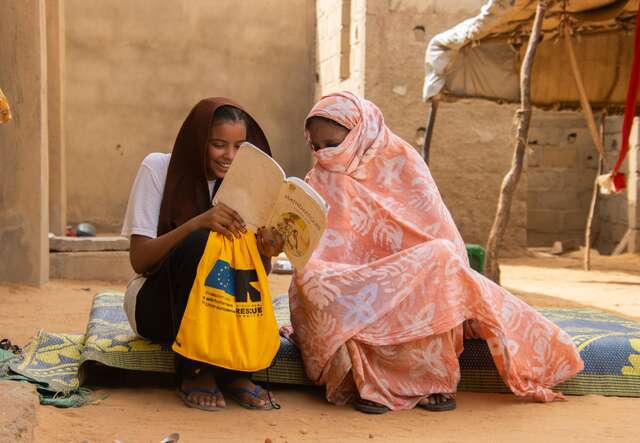 Gao, Mali. Samah, 15, showing a passage in her book to her grandmother.