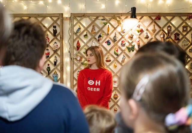 Woman wearing a christmas jumper and children visiting a christmas decoration factory