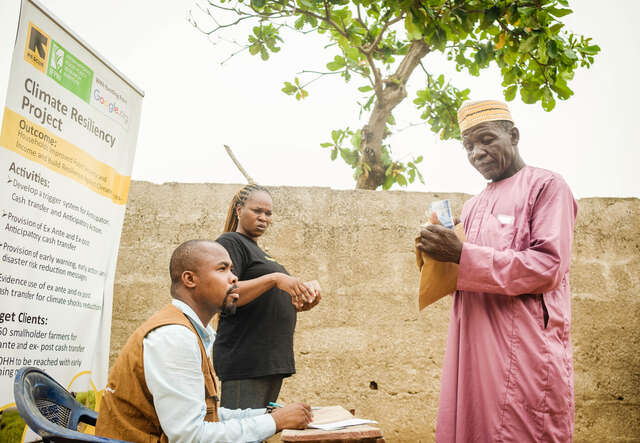 En man kollar på pengar han fått i kontantstöd från RESCUE.