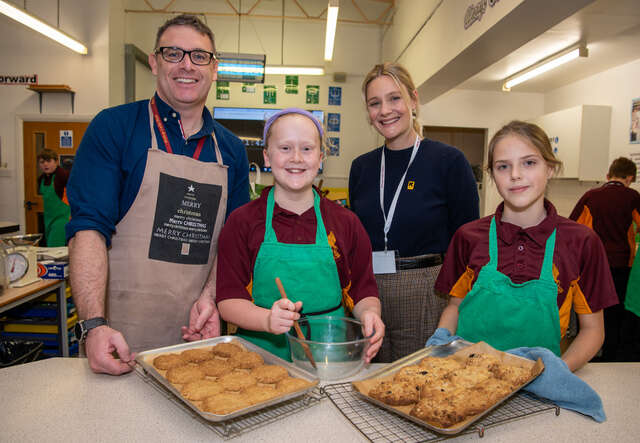 Romola Garai with students and their teacher at a school participating in the Healing Classrooms program