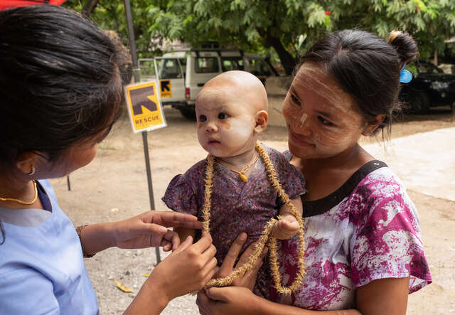 Ett spädbarn, Shwe Poe, med sin mamma Nan Ei, får medicinsk behandling av RESCUE:s mobila klinik i Mandalay-regionen efter den kraftiga jordbävningen i Myanmar.