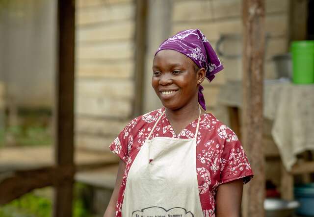 A woman is standing and smiling 