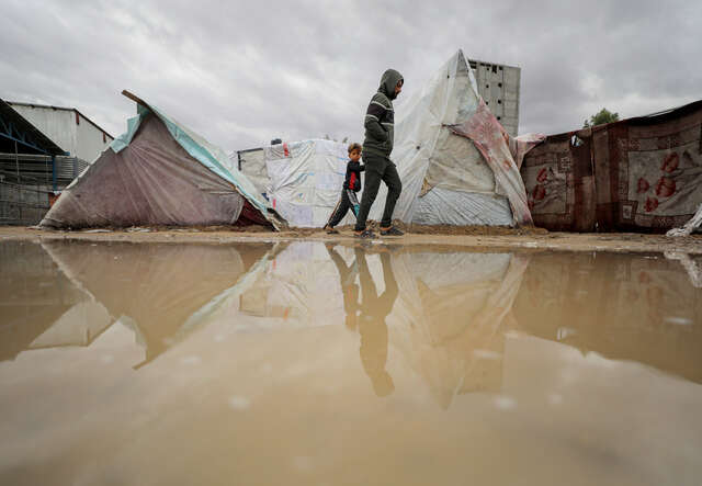 A reflection of Palestinians living in makeshift tents, struggling with harsh weather conditions amid Israeli attacks in Deir al-Balah, Gaza.