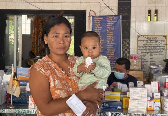 A mother holds her young child in her arms as they visit an IRC medical clinic in Myanmar.