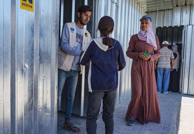 A Palestinian family receives new winter clothing at an IRC distribution point in Gaza.